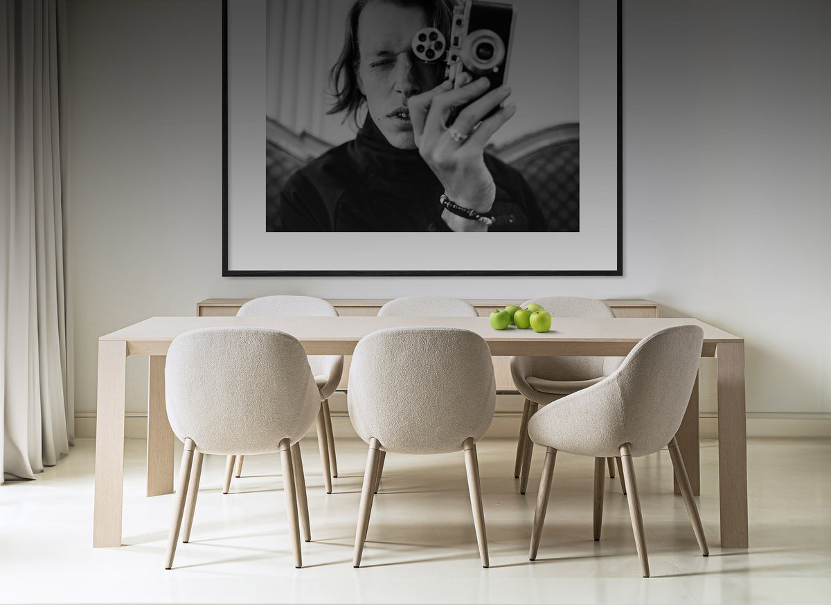 Domicile New Edition - A residential furniture collection by Michael Vanderbyl. A modern room with a Scandinavian vibe containing a light brown wooden table surrounded by 6 white upholstered chairs.