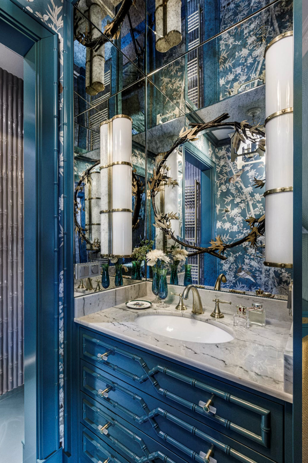 Bathroom with blue vanity, mirror, and decorative elements