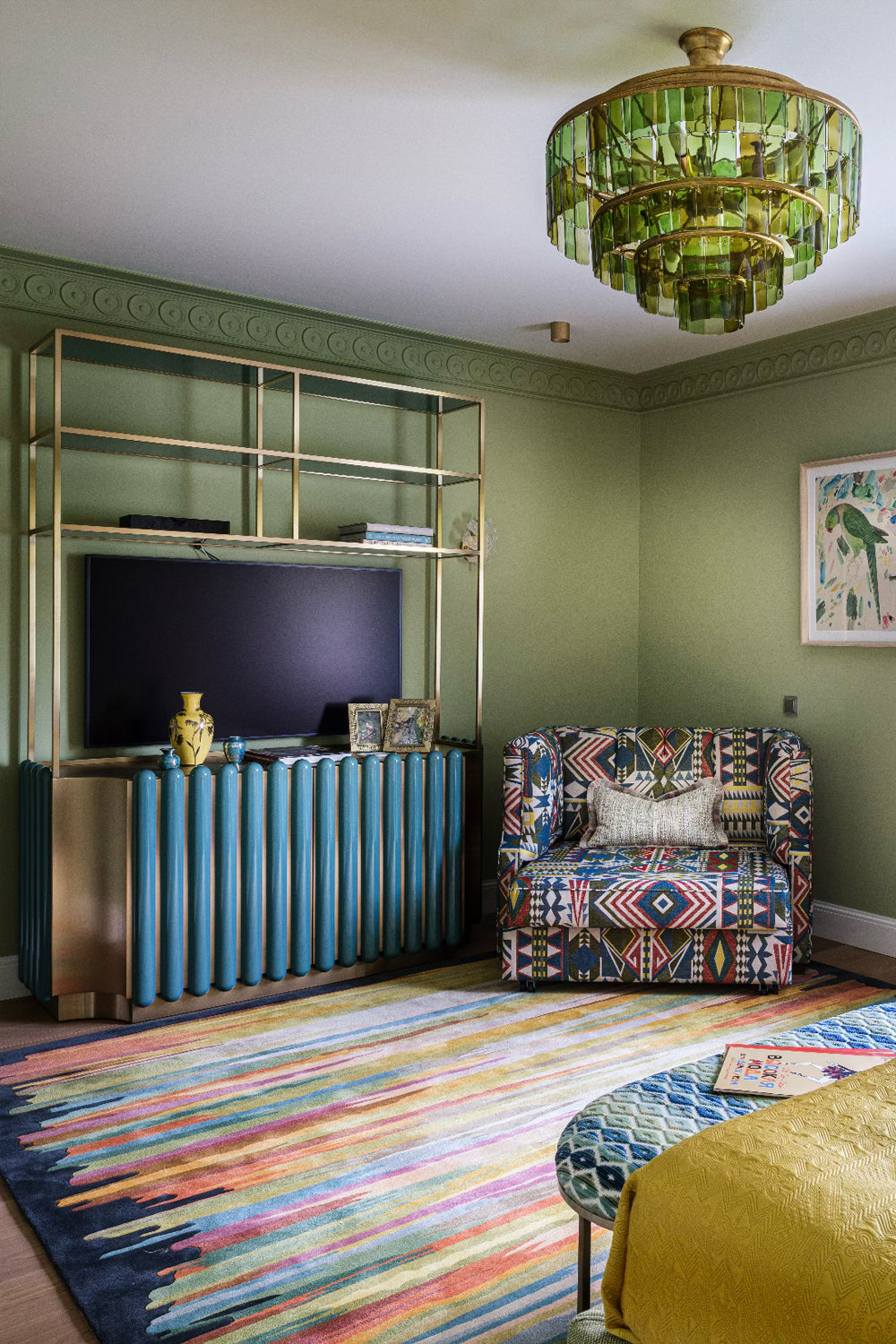 Modern living room with colourful striped  rug, patterned upholstered armchair, and decorative ceiling pendant.
