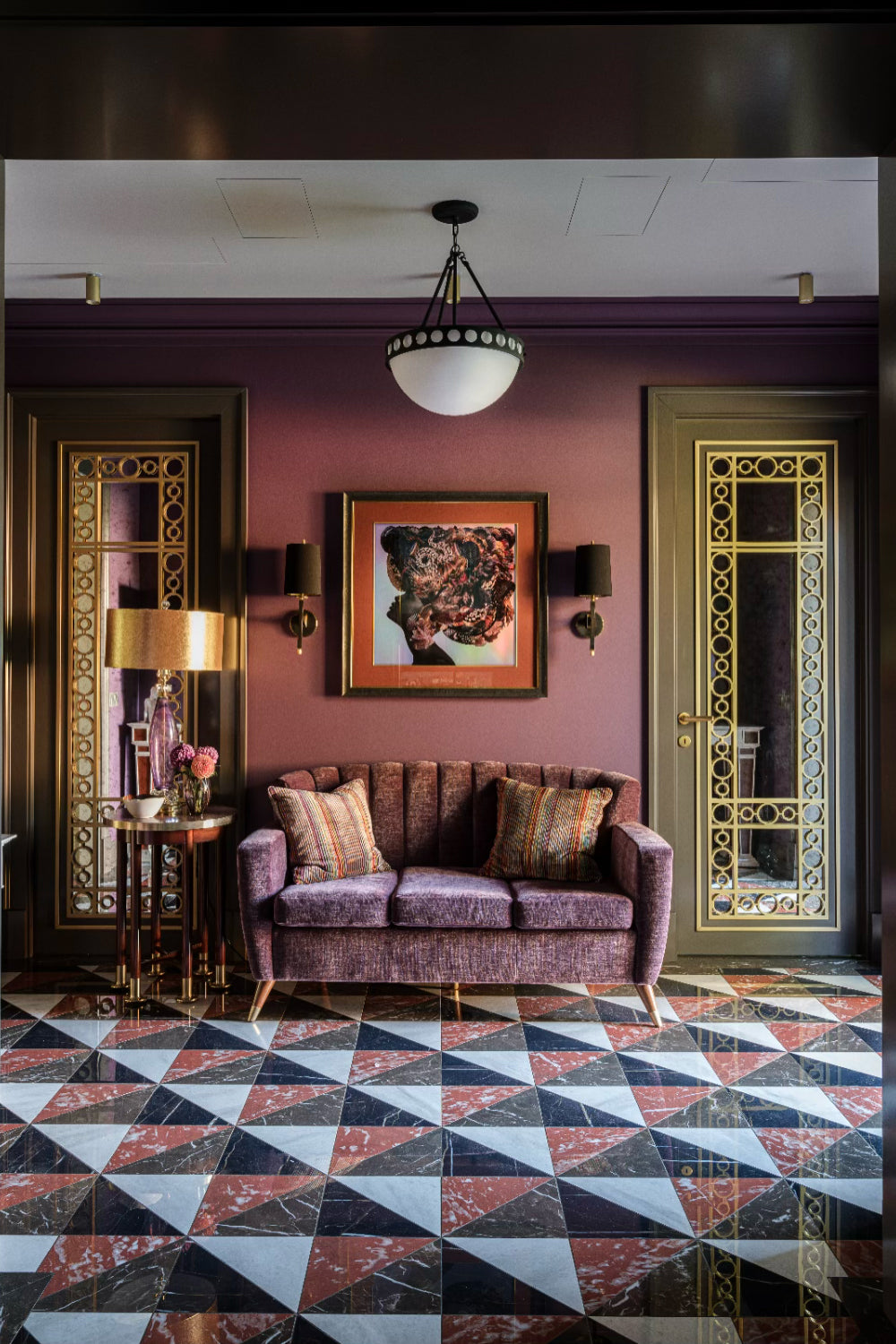 Decorative interior with a purple upholstered sofa, patterned floor, and wall art.
