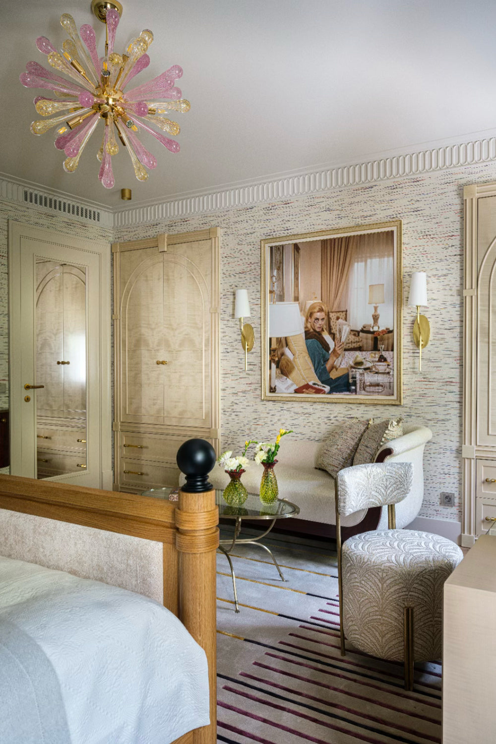 Luxurious bedroom with a chandelier, bed, and sitting area.