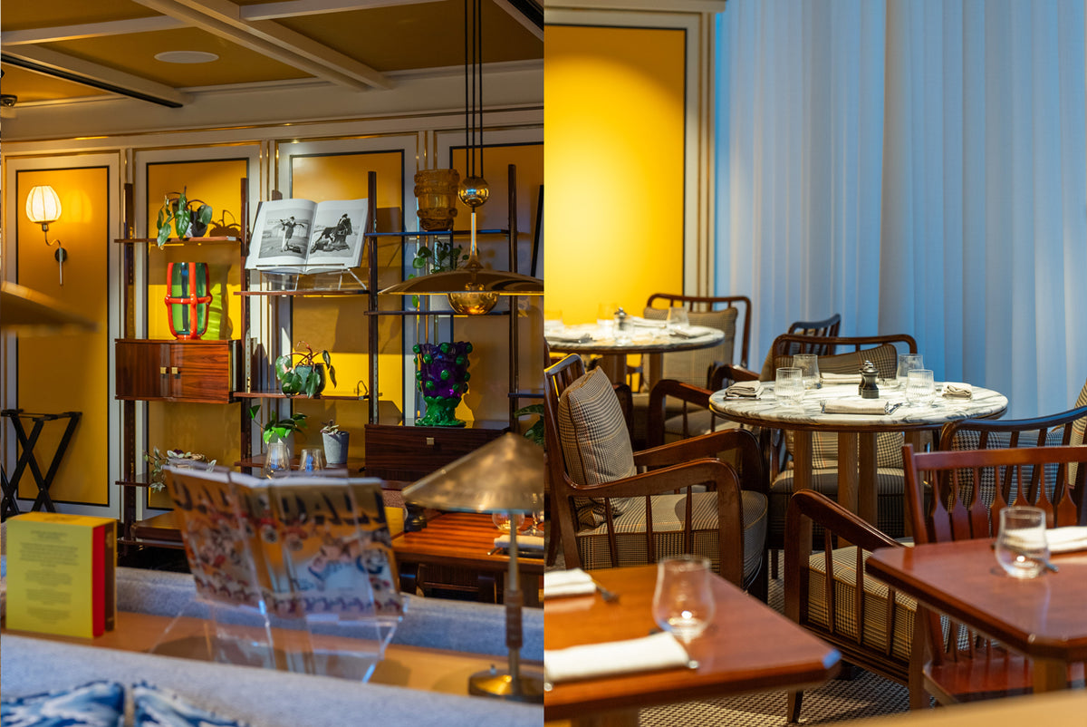 A split-view interior scene showing a warmly lit dining space with wooden tables, chairs, shelving, and yellow walls on the left, and a white curtain-covered window area with dining tables on the right.